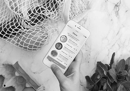 téléphone à côté d'un panier de légumes