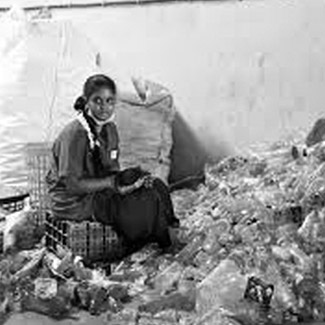 Une femme assise parmis des déchets
